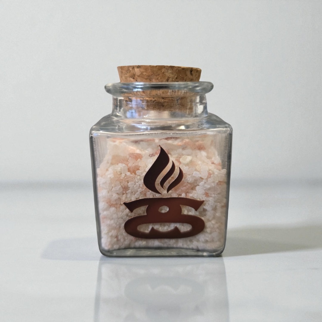 Lime, Grapefruit and Geranium Simple Scents Minis Essential Oil Bath Salts and Foot Soak - 50g small square clear glass jar with cork stopper filled with pale pink Himalayan bath salts, Simple Scents dark logo on front, front view on light grey background