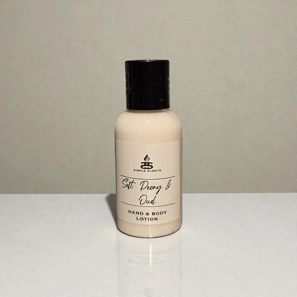 Simple Scents Minis Soft Peony & Oud Hand & Body Lotion 50ml - small white bottle with black cap and Simple Scents label, front view on white surface with light grey background