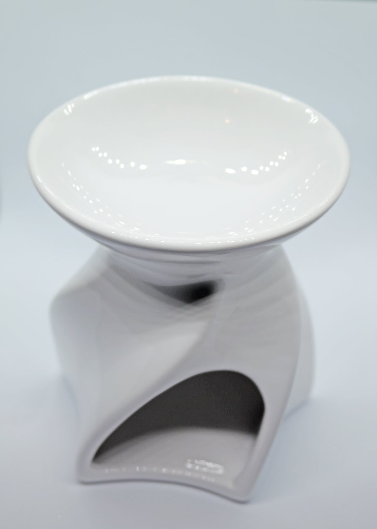 Lyon Ceramic Tea Light Wax Burner - gloss white twisted spiral Lyon ceramic wax burner with empty white dish on light blue background