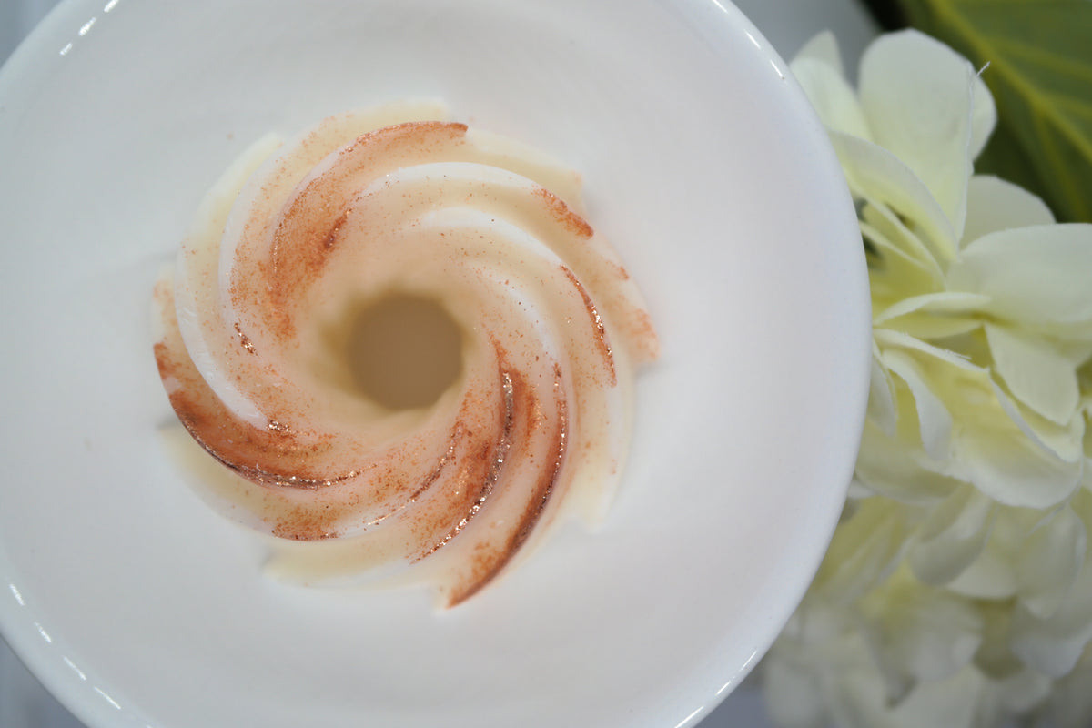 Lyon Ceramic Tea Light Wax Burner - top down view of cream Simple Scents Ambience twirl soy wax melt with rose gold shimmer melting in white Lyon ceramic dish, with white hydrangea flowers beside it