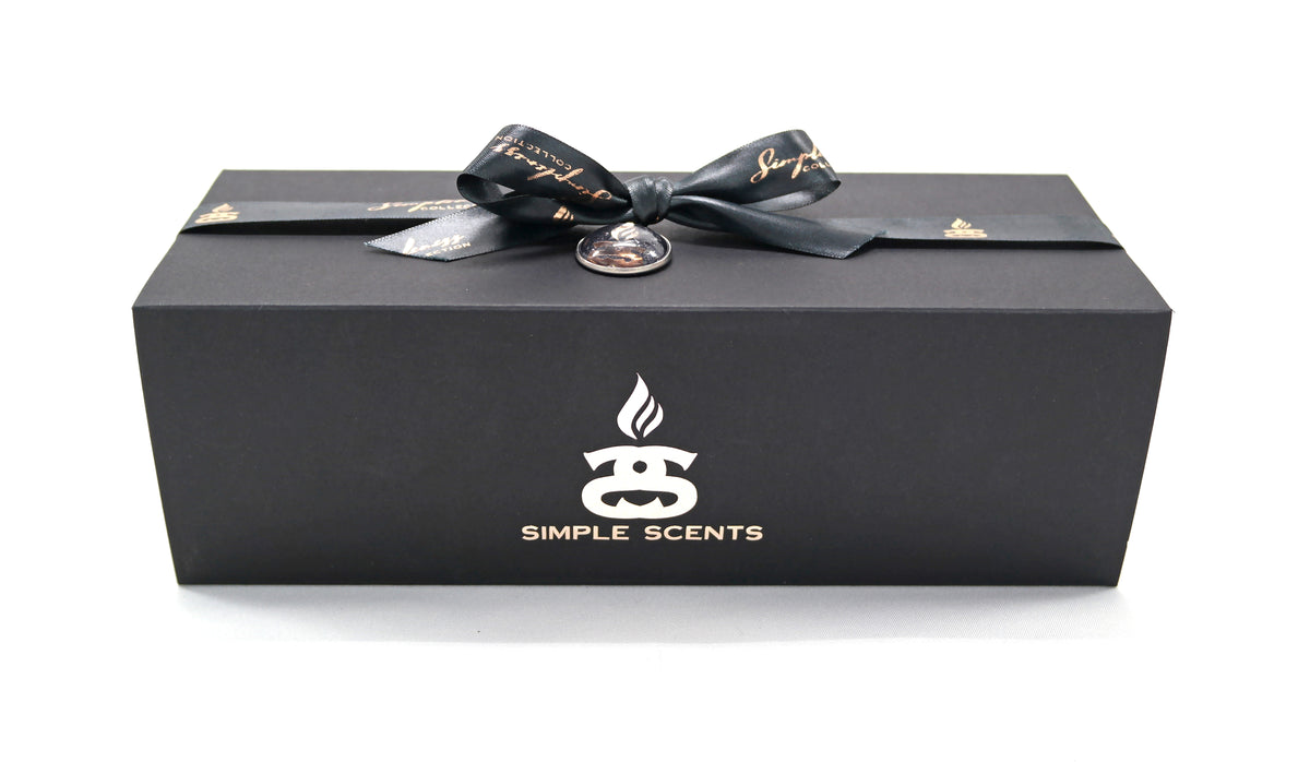 Simple Scents Mini Indulgence Trio Luxury Soy Candles 75g - matte black rectangular Simple Scents gift box tied with black satin ribbon bow and jewelled brooch, white Simple Scents logo on front, on white background