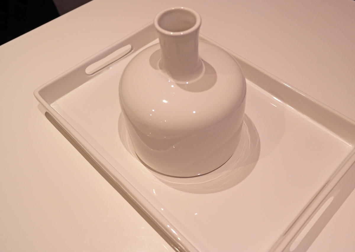 Gloss-white Riley ceramic vase displayed on a white rectangular tray, showing its rounded shoulders and narrow neck.