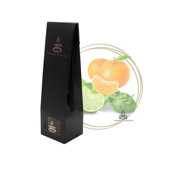 Lime Basil and Mandarin Simple Scents Excellence Reed Diffuser - matte black tall tapered packaging box with rose gold Simple Scents logo, displayed in front of mandarin oranges, lime slices and fresh basil leaves inside a gold double-ring circle frame on white background