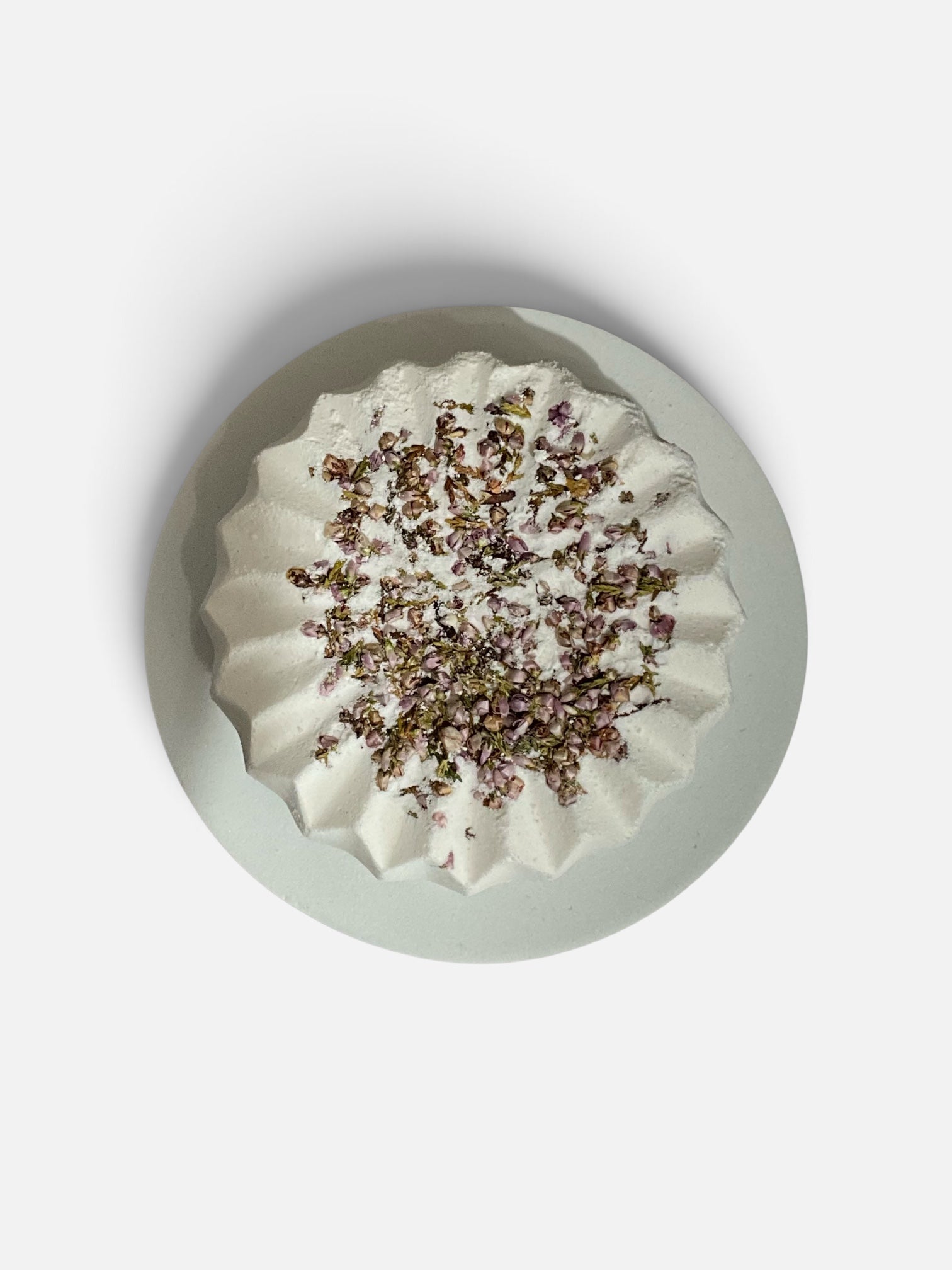 Simple Scents Tea Tree and Rosemary Aromatherapy Bath Bomb topped with dried heather flower botanicals, overhead view on a white background