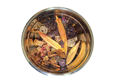 Overhead view of Rouge Hibiscus Boujee Potpourri blend in a silver bowl showing rich plum, amber and burgundy dried botanics against a white background