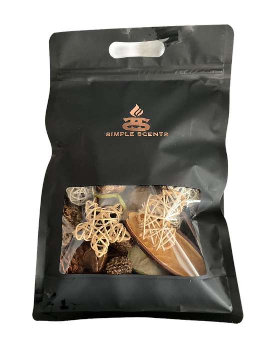 A black resealable stand-up pouch with a clear window showing dried botanicals and wooden scent pieces inside. The pouch has a handle cutout at the top and a printed Simple Scents logo in gold near the upper center.